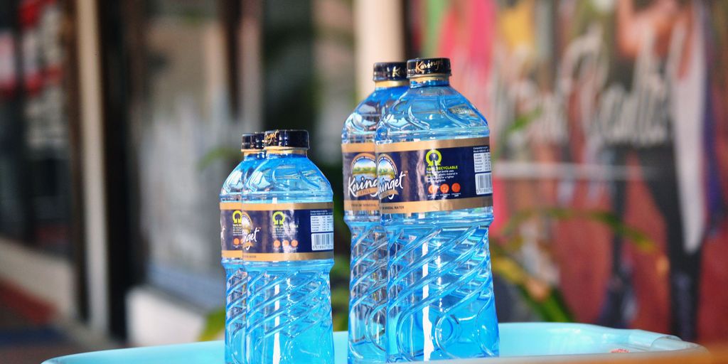 blue tonic bottle with measuring tape and fresh fruits