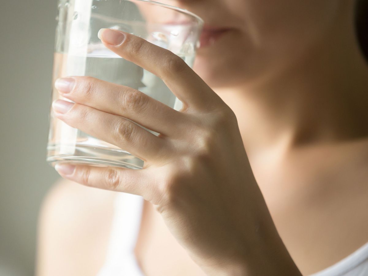 person drinking water while on the go