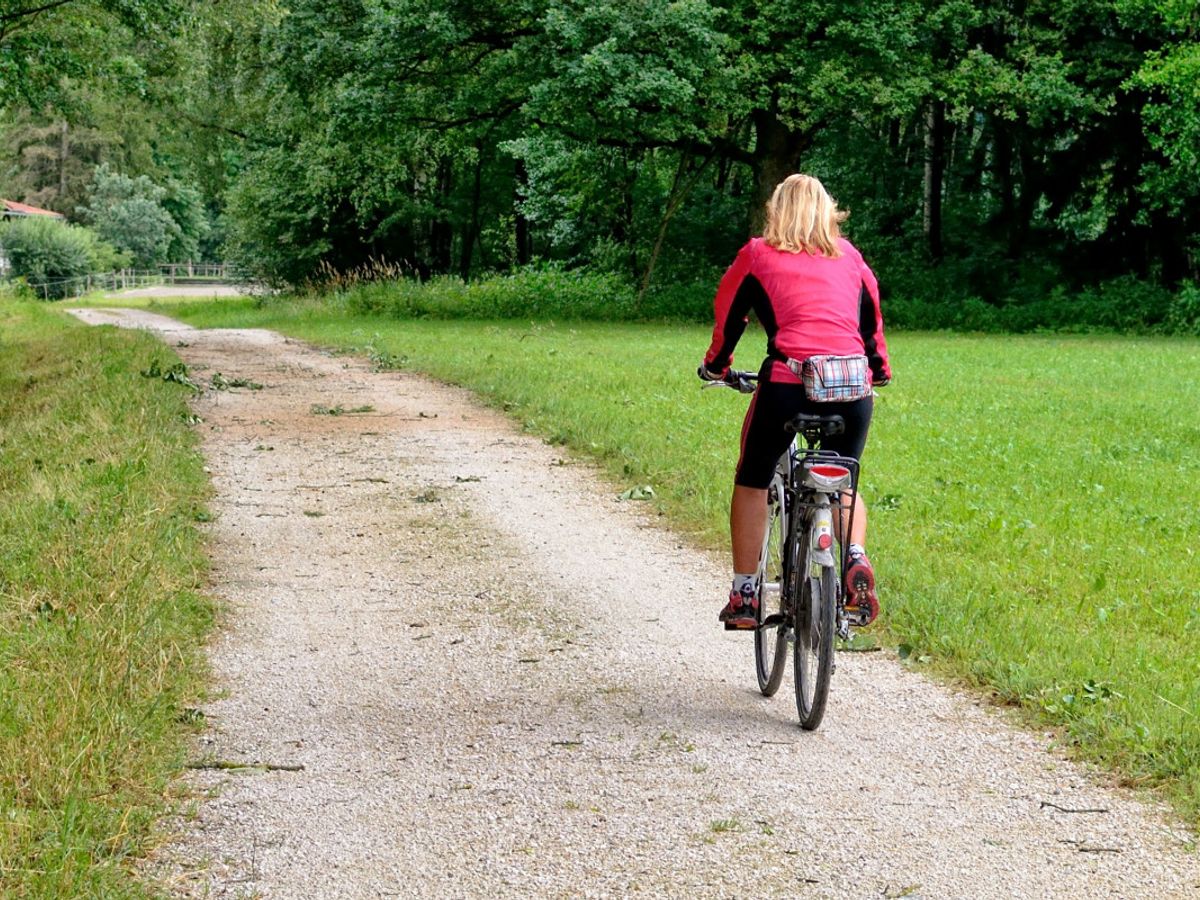 person cycling on a scenic trail for weight loss