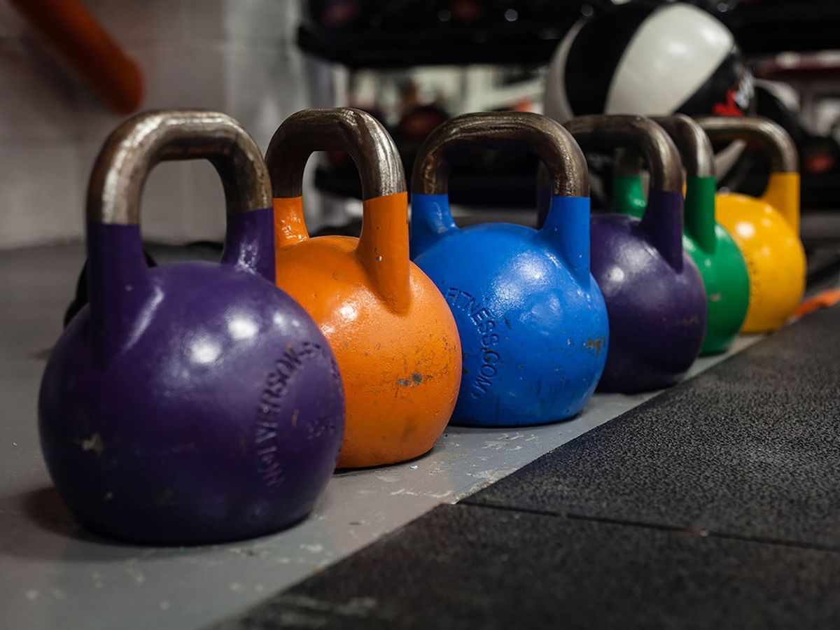 fit woman lifting weights in a gym, emphasizing strength and muscle building, with a focus on weight loss and debunking myths