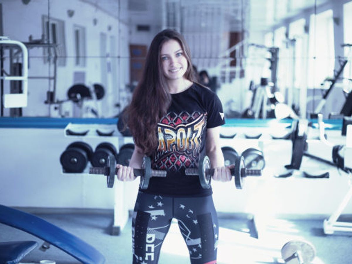 fit woman lifting weights in a gym